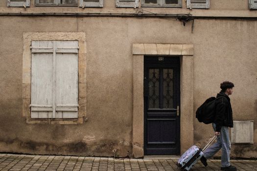 Person heading out the door with a backpack and bag
