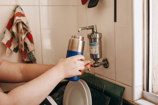 Person filling a bottle with filtered water
