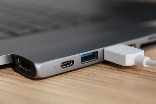 USB-C cable plugged into a device next to a laptop