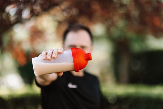 Person holding a shaker bottle mixed with collagen powder