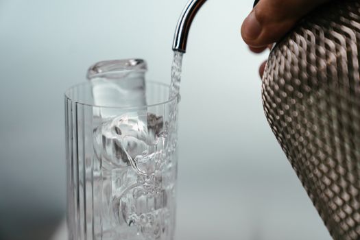 Ice cubes pouring into a glass of water