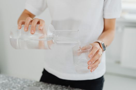 Checking a glass of water and a digital reading at a kitchen counter