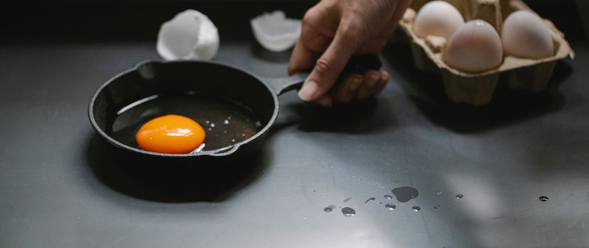 Person seasoning a cast iron pan in a kitchen
