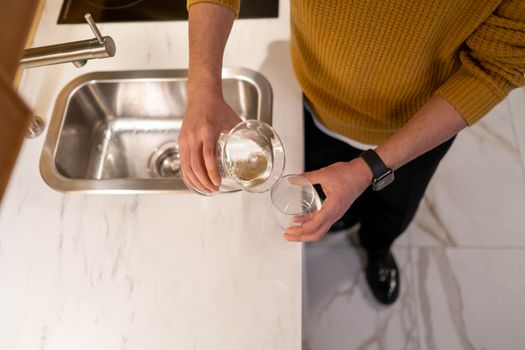 Person pouring hydrogen-enriched water into a glass
