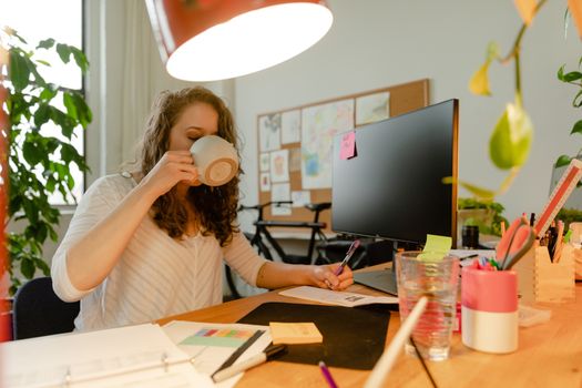 Person drinking water at a home office desk
