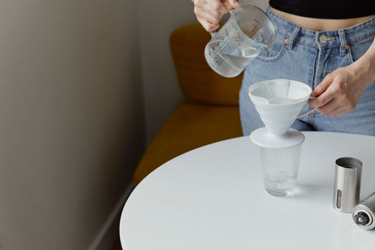 Person pouring a glass of water in a kitchen