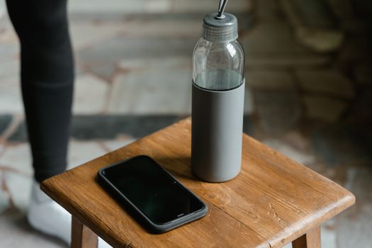 Portable hydrogen water bottle and phone on a wooden stool