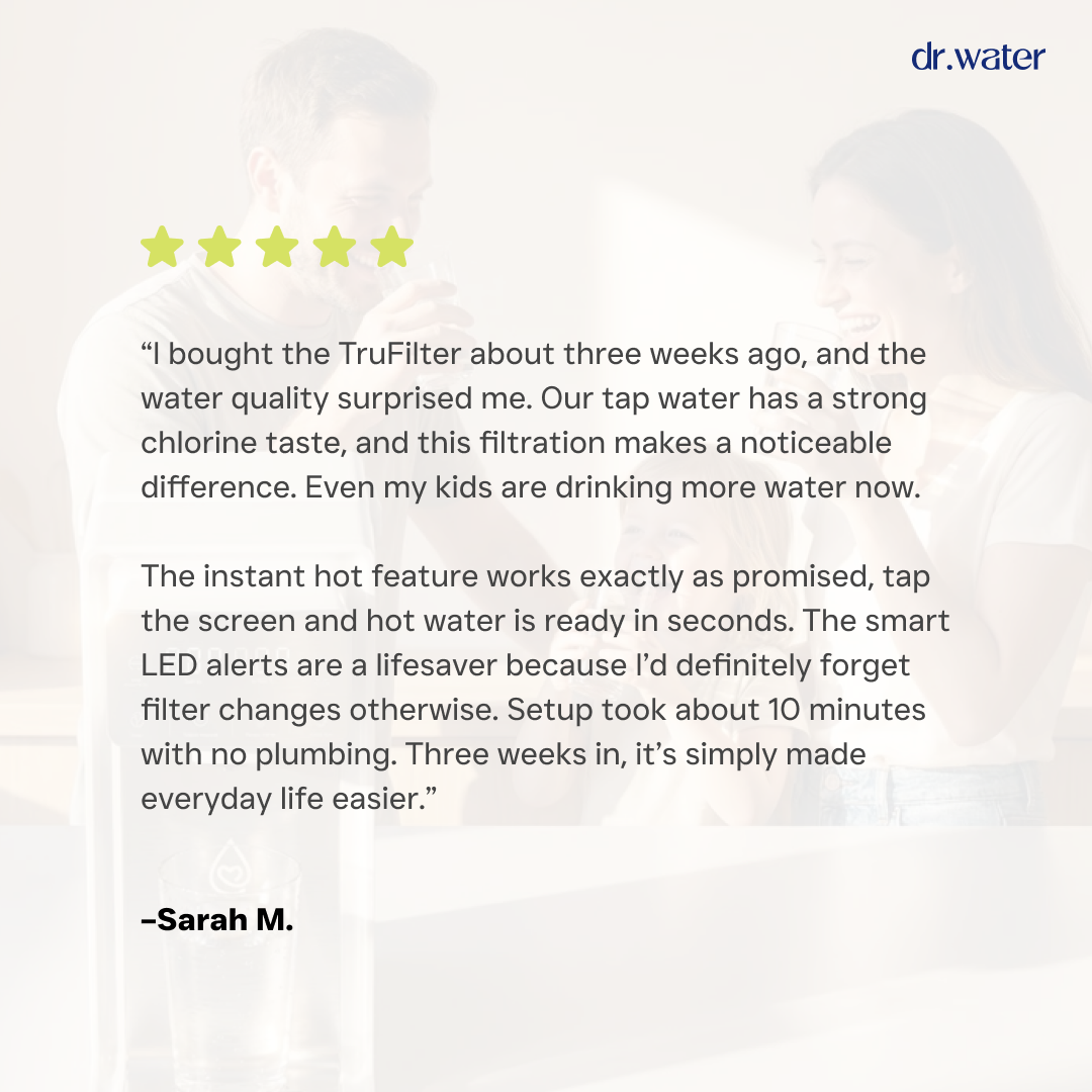 Dr.Water TruFilter customer review card on a dim photo background with five gold stars and dr.water wordmark, featuring Sarah M.'s testimonial about reduced chlorine taste, instant hot water, smart LED filter alerts and a 10-minute setup with no plumbing.